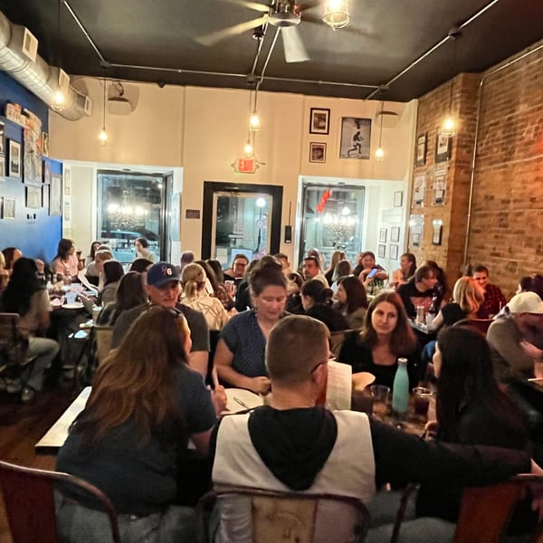 A bustling Urban Burger dining room filled with diverse patrons enjoying their meals under warm lighting.